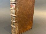 an old book sitting on top of a table next to a gray background