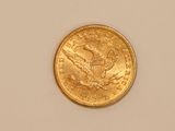 a close up of a gold coin on a white surface
