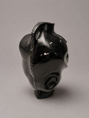 une petite statue d'éléphant noir posée sur une surface blanche