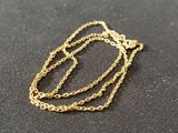 a close up of a gold chain necklace on a black surface