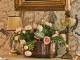 un vase de fleurs posé sur une table à côté d'une lampe