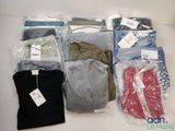 beaucoup de vêtements rangés dans des sacs posés sur la table