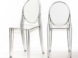 deux chaises en plastique transparent placées l'une à côté de l'autre sur une surface blanche