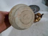 une personne tenant dans la main un bol muni d'une anse