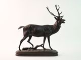 statue d'un cerf debout sur un socle en bois, sur fond blanc