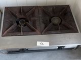 une plaque de cuisson en métal à deux feux, sur laquelle est apposée une étiquette