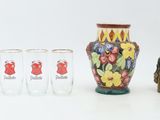 four glasses and a vase sitting next to each other on a table