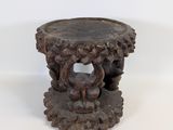 une table en bois ornée de sculptures sur un plateau blanc
