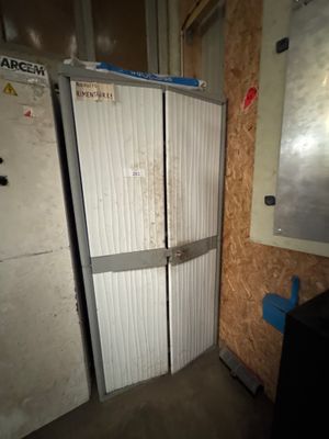un réfrigérateur dans un coin d'une pièce aux murs en contreplaqué