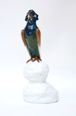 a figurine of a bird sitting on top of a pile of snow