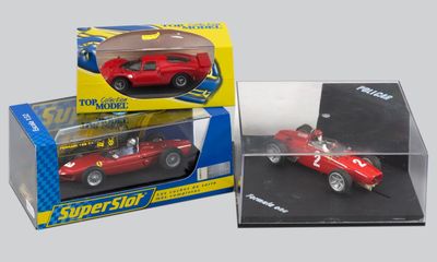 une petite voiture rouge dans une vitrine posée sur une table