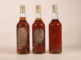 three bottles of alcohol sitting next to each other on a table