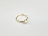 a close up of a ring with a pearl on it