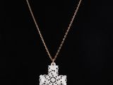 a white cross pendant on a gold chain on a mannequin mannequin mannequin mannequin mannequin mannequin mannequin mann