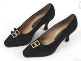 une paire de chaussures noires avec une boucle dorée au talon