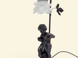 une image représentant la statue d'un garçon tenant une lampe