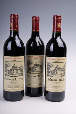 three bottles of red wine are lined up on a white surface