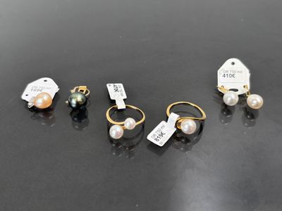 trois paires de boucles d'oreilles et une étiquette sur un fond noir
