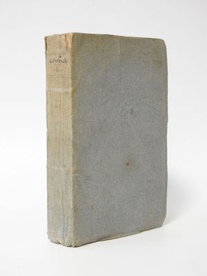 an old book sitting on top of a white table next to a white wall