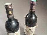 two bottles of wine sitting next to each other on a table