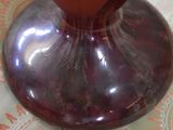 a purple vase sitting on a table with a paisley tablecloth