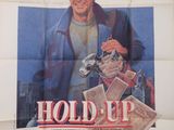 L'affiche du film « Hold Up » est accrochée au mur.