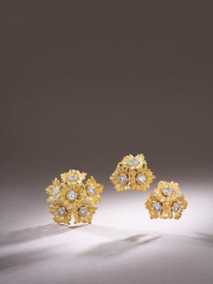 a pair of gold and diamond earrings on a white surface