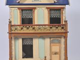 une petite maison de poupées avec un toit bleu sur fond blanc