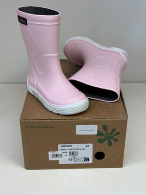 une paire de bottes de pluie roses posée sur une boîte en carton