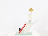 a small sculpture of a man on a surfboard on top of a table