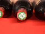 four bottles of wine are lined up on a red surface