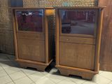 two tall wooden cabinets with glass doors on them