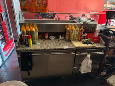 une photo d'une cuisine avec de nombreux condiments posés sur le plan de travail