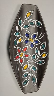 une assiette décorative accrochée au mur, ornée d'un motif floral