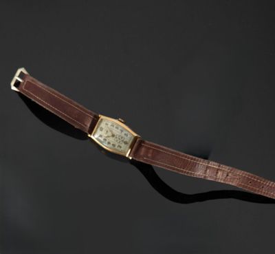 gros plan d'une montre sur une surface noire avec un fond noir