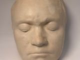 a sculpture of a man ' s face on a white surface