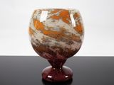 a glass vase with a red base on a table