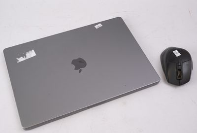 un ordinateur portable et une souris posés sur une surface blanche