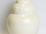a white vase that is sitting on a white surface