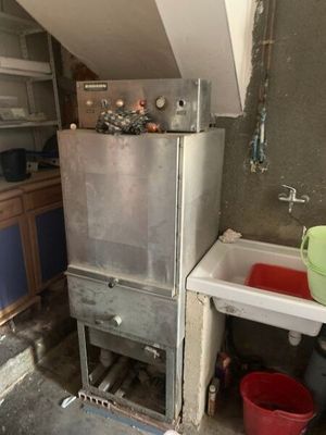 une photo d'une cuisine sale avec une cuisinière et un évier
