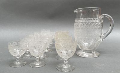 cinq verres et un pichet posés sur une table