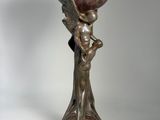 statue of a woman holding a bowl on her head on a pedestal