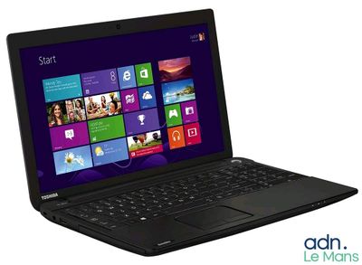 un ordinateur portable posé sur une surface blanche