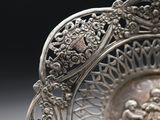 a silver plate with a design on it on a table