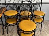 six black and yellow chairs with yellow cushions in a room