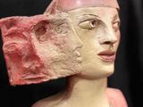 a statue of a woman with a pink hat on it ' s head