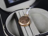 a gold locke in a case on a black table