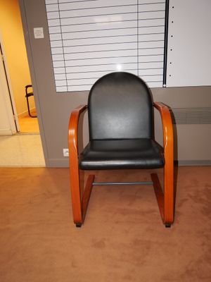 un fauteuil en cuir noir avec une structure en bois dans une pièce
