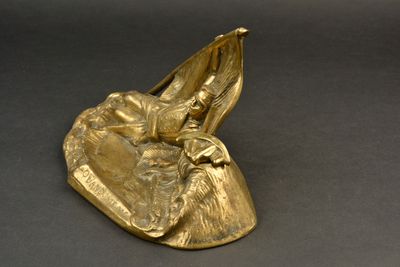 figurine en laiton représentant une femme dans un bateau sur lequel se trouve un oiseau