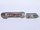 two toy trains sitting next to each other on a white surface